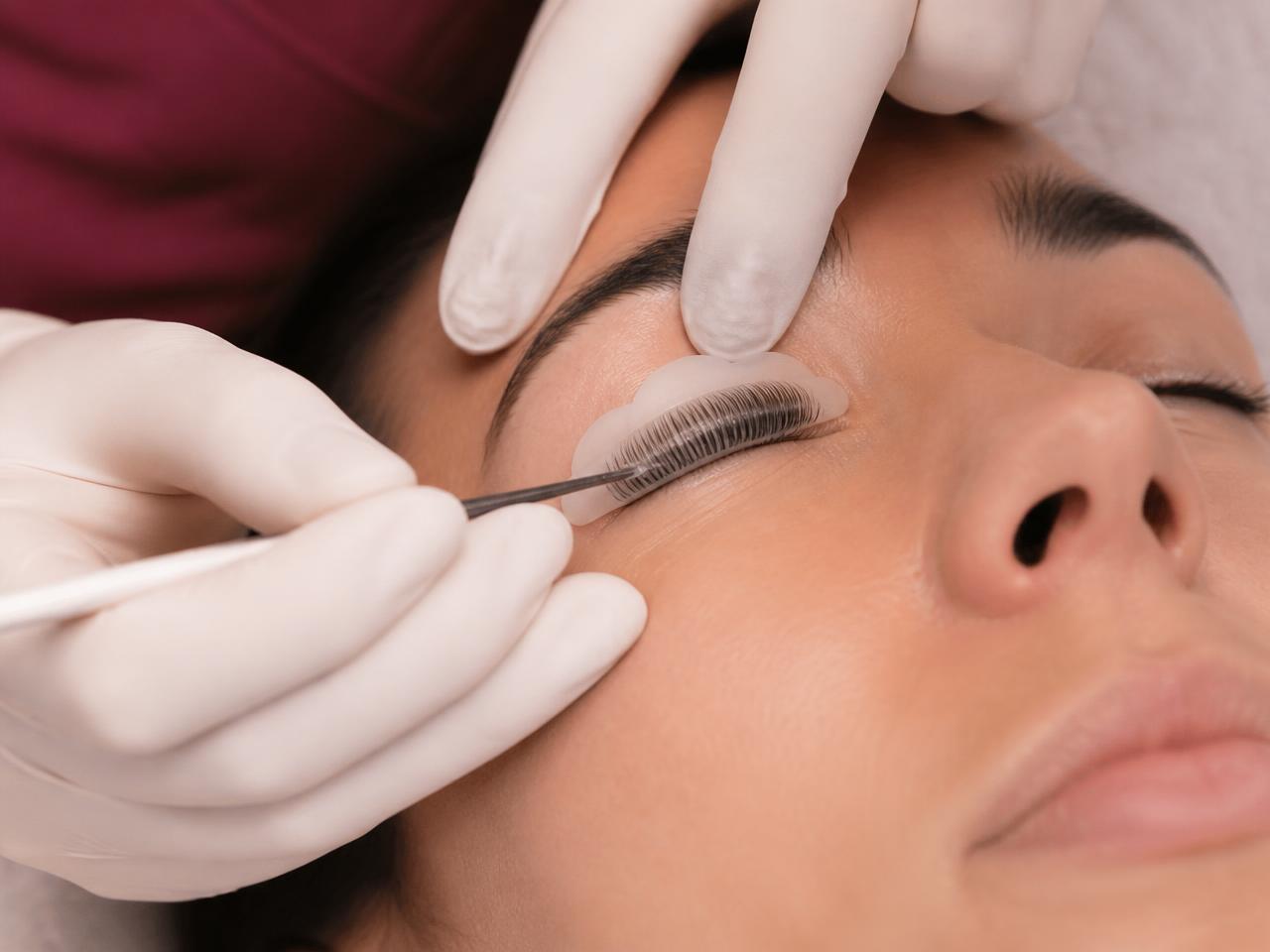 Lash lift and tint course showing lashes being placed on a silicone shield during treatment.