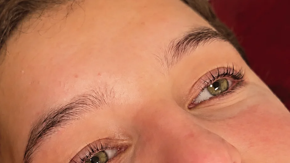 Close-up of both eyes and groomed brows after a lash lift, with no caption text in the photo