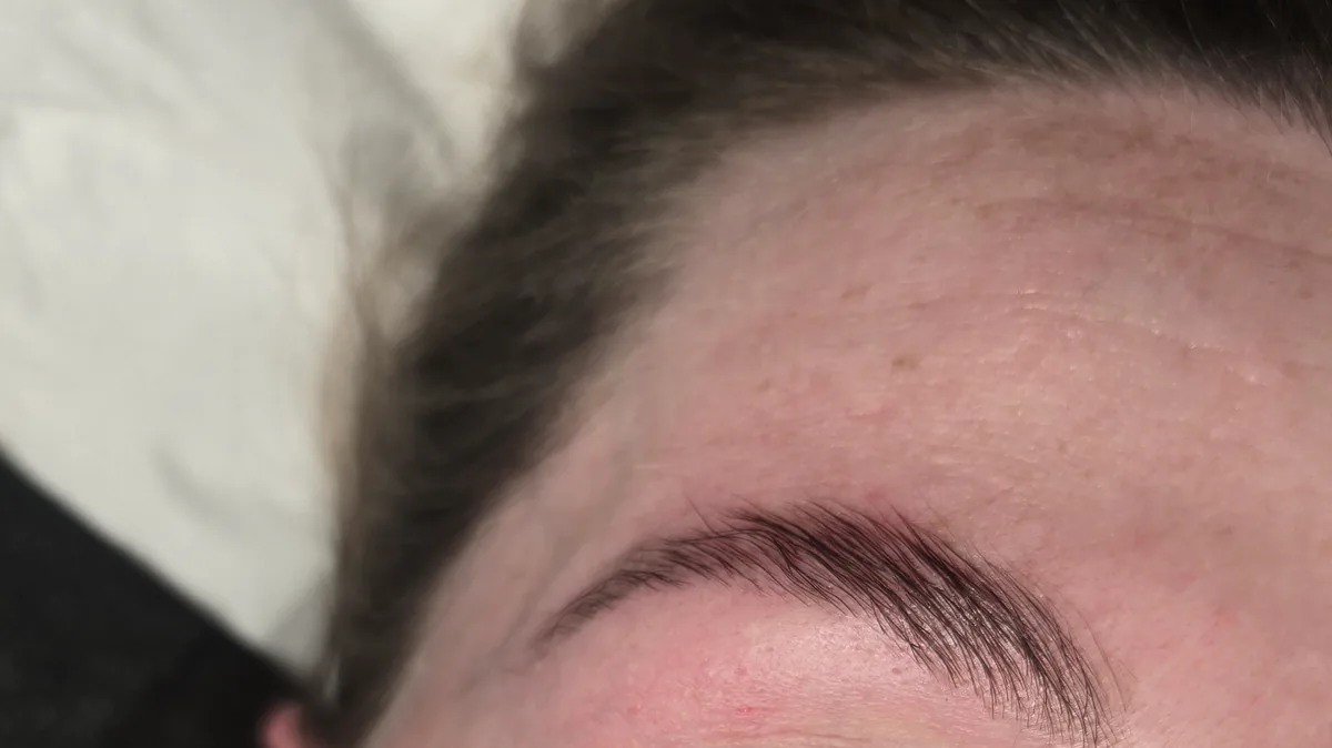 Upright close-up of lifted lashes and groomed brows after lash and brow treatment